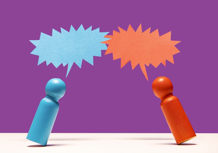 blue and red figurines lean toward each other with spiky matching speech bubbles