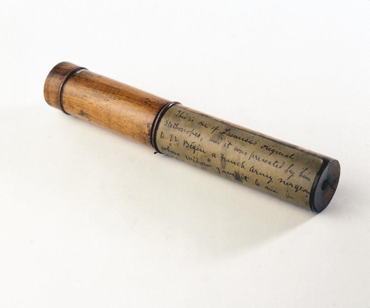 Wooden tube with writing wrapped around one side