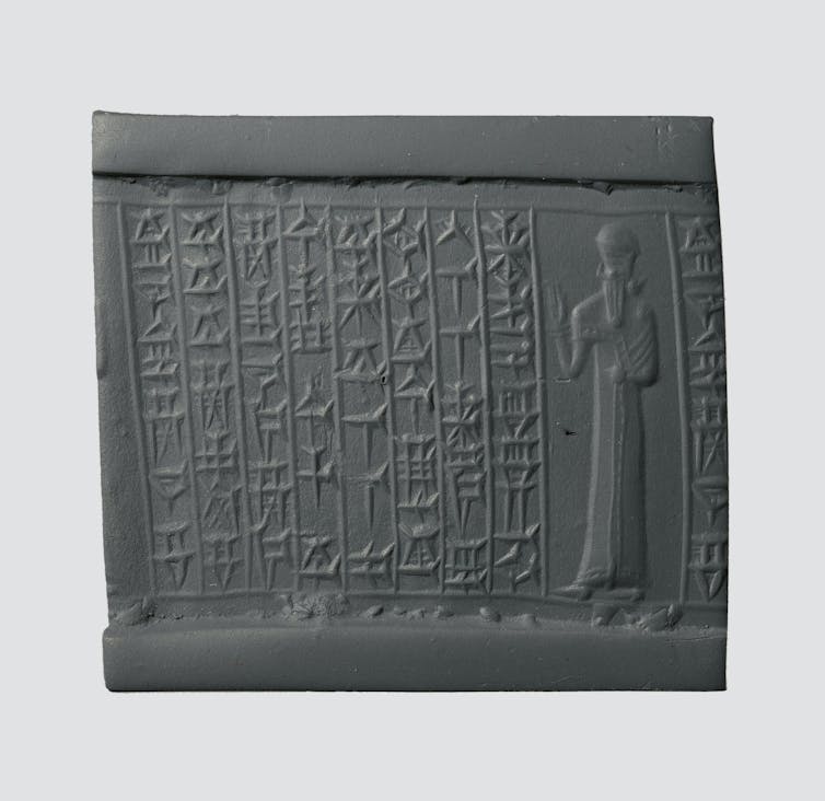 Scan of an artifact with columns of glyphs and a figure depicted on the far right