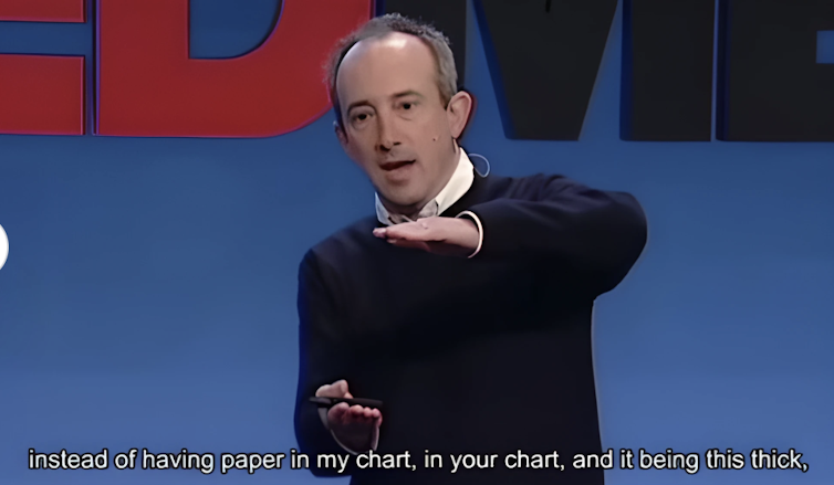 man speaking holds his hands apart